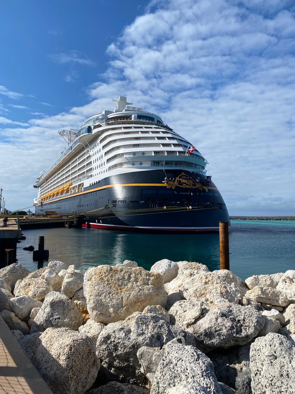 Navio Disney Dream atracado nas Bahamas, com mar azul e céu aberto, destacando a experiência do cruzeiro Disney