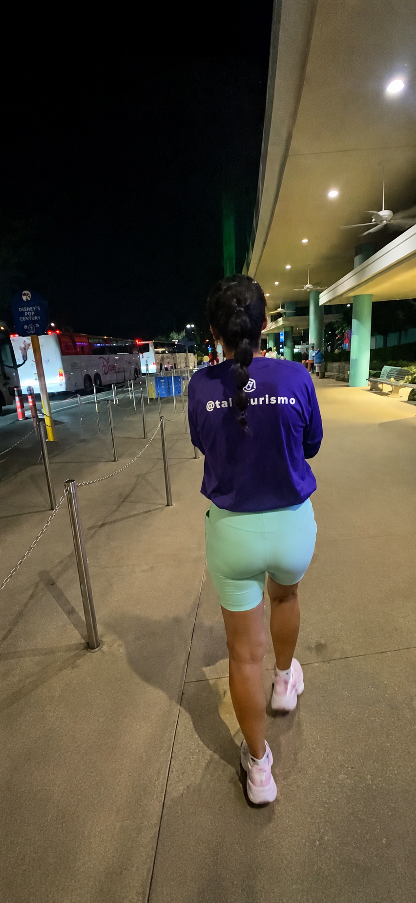 Corredora caminhando pelo Disney's Pop Century Resort ainda de madrugada a caminho do transporte para uma corrida runDisney em Orlando