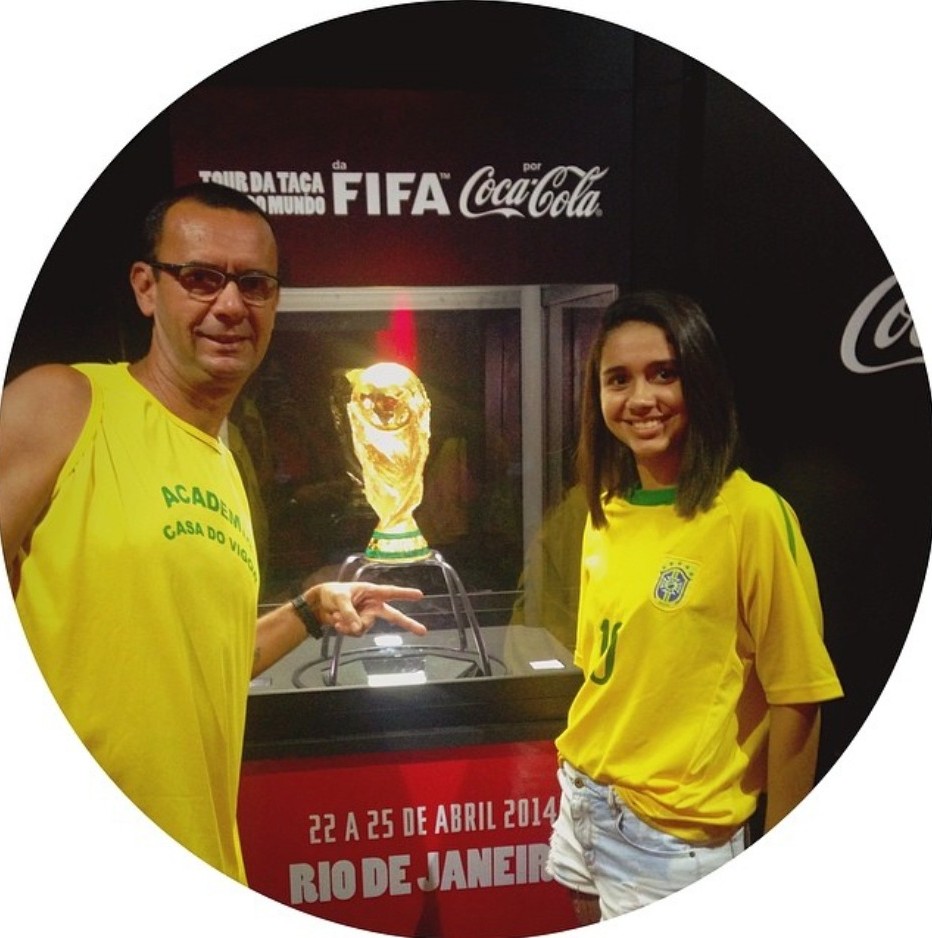 Beatriz Vicente da Talla Turismo ao lado do troféu oficial da Copa do Mundo FIFA durante evento da FIFA no Rio de Janeiro em 2014, experiência ligada ao clima do Mundial e turismo esportivo
