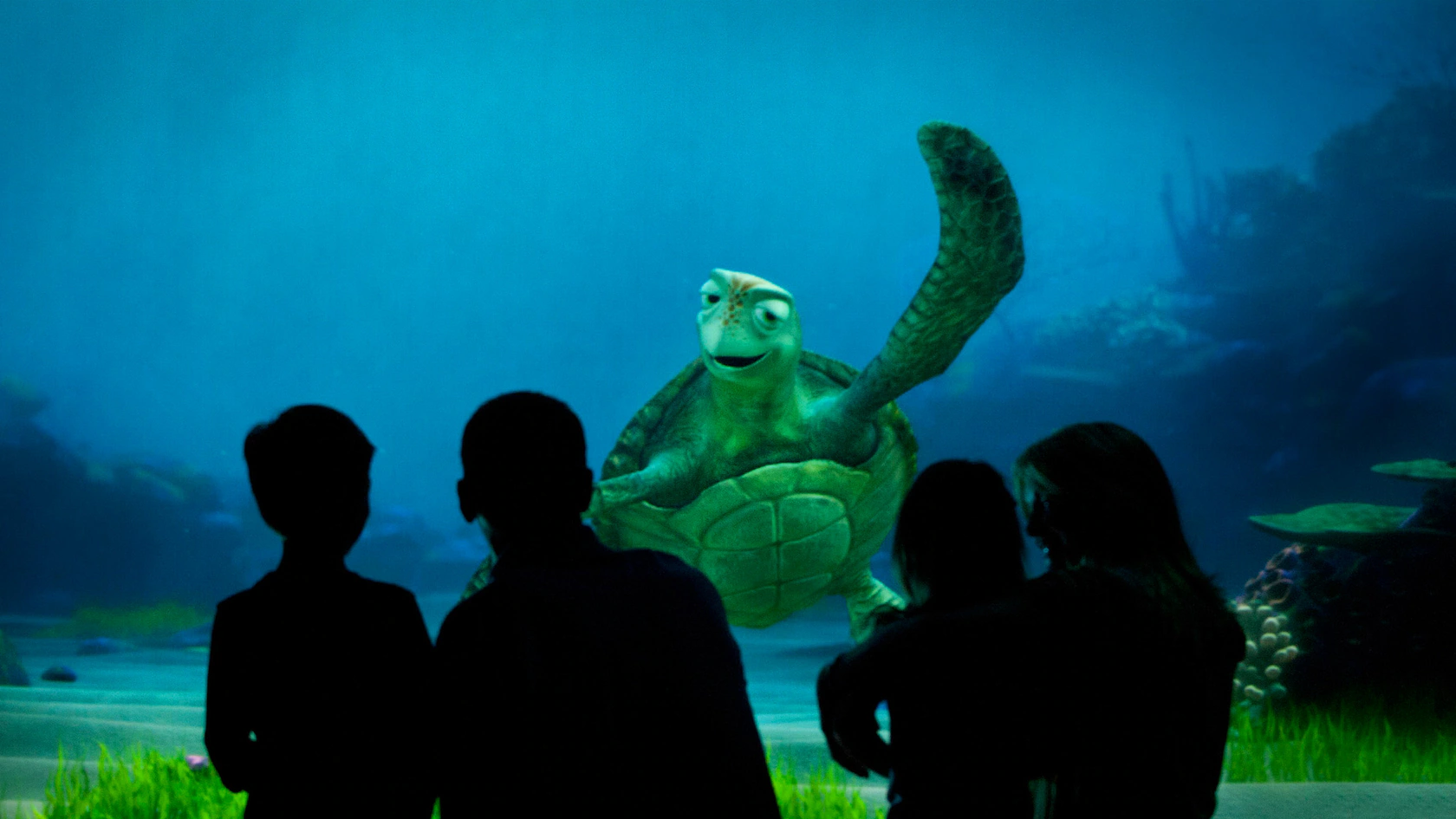 Crianças assistindo ao Crush durante a experiência Turtle Talk With Crush no EPCOT