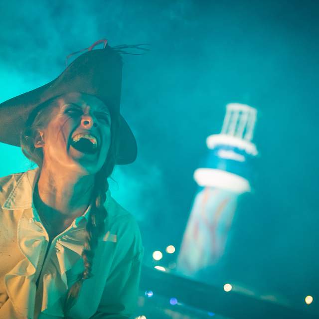 Personagem assustadora caracterizada como pirata durante o Howl-O-Scream no SeaWorld Orlando, cercada por fumaça e iluminação temática de Halloween na Flórida.