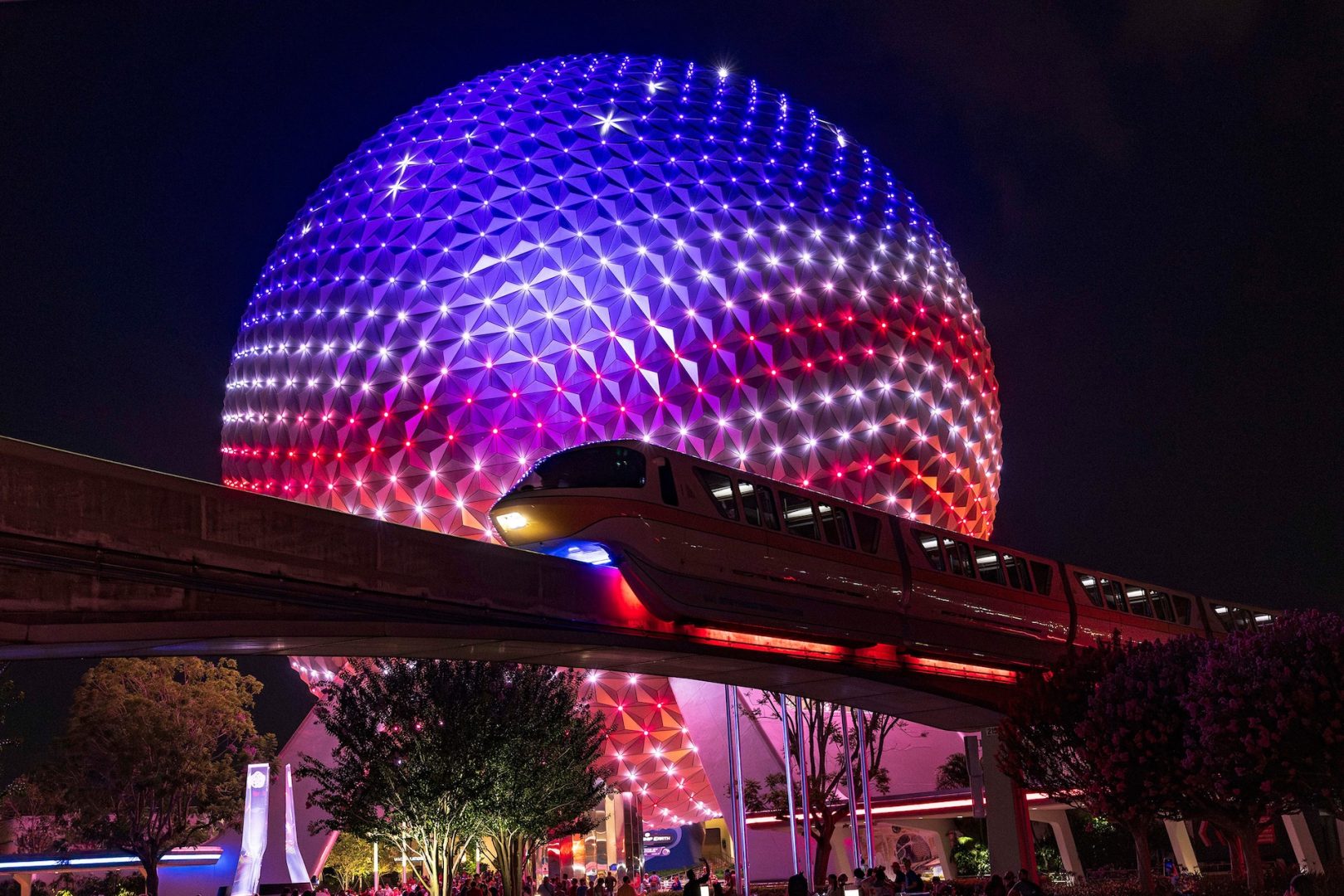 Spaceship Earth iluminada em vermelho, branco e azul durante as comemorações do 4 de julho no EPCOT, em Orlando.