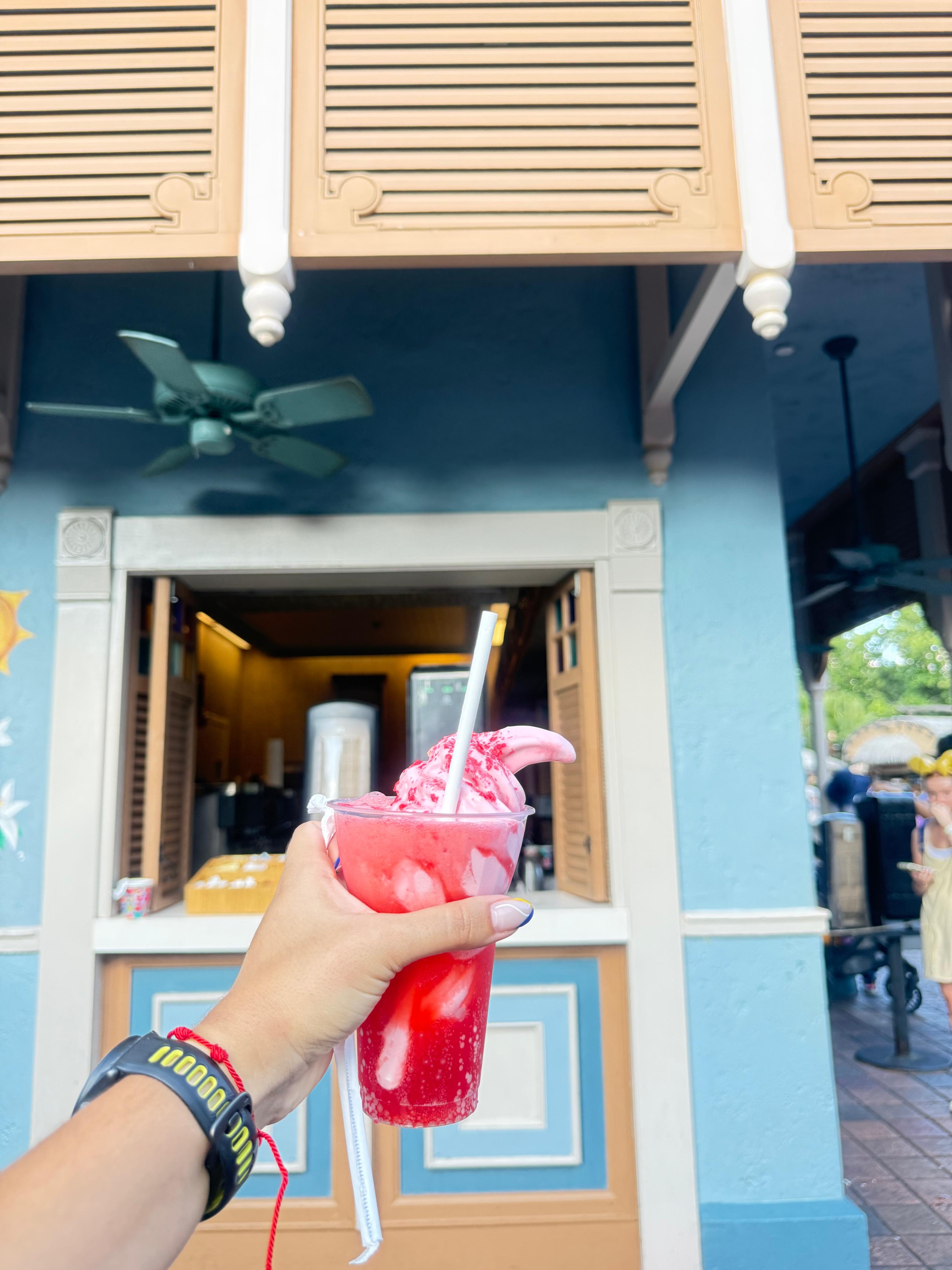 Snack gelado do Walt Disney World segurado por uma visitante, exemplo de item que pode ser resgatado com créditos de Snack do Disney Dining Plan