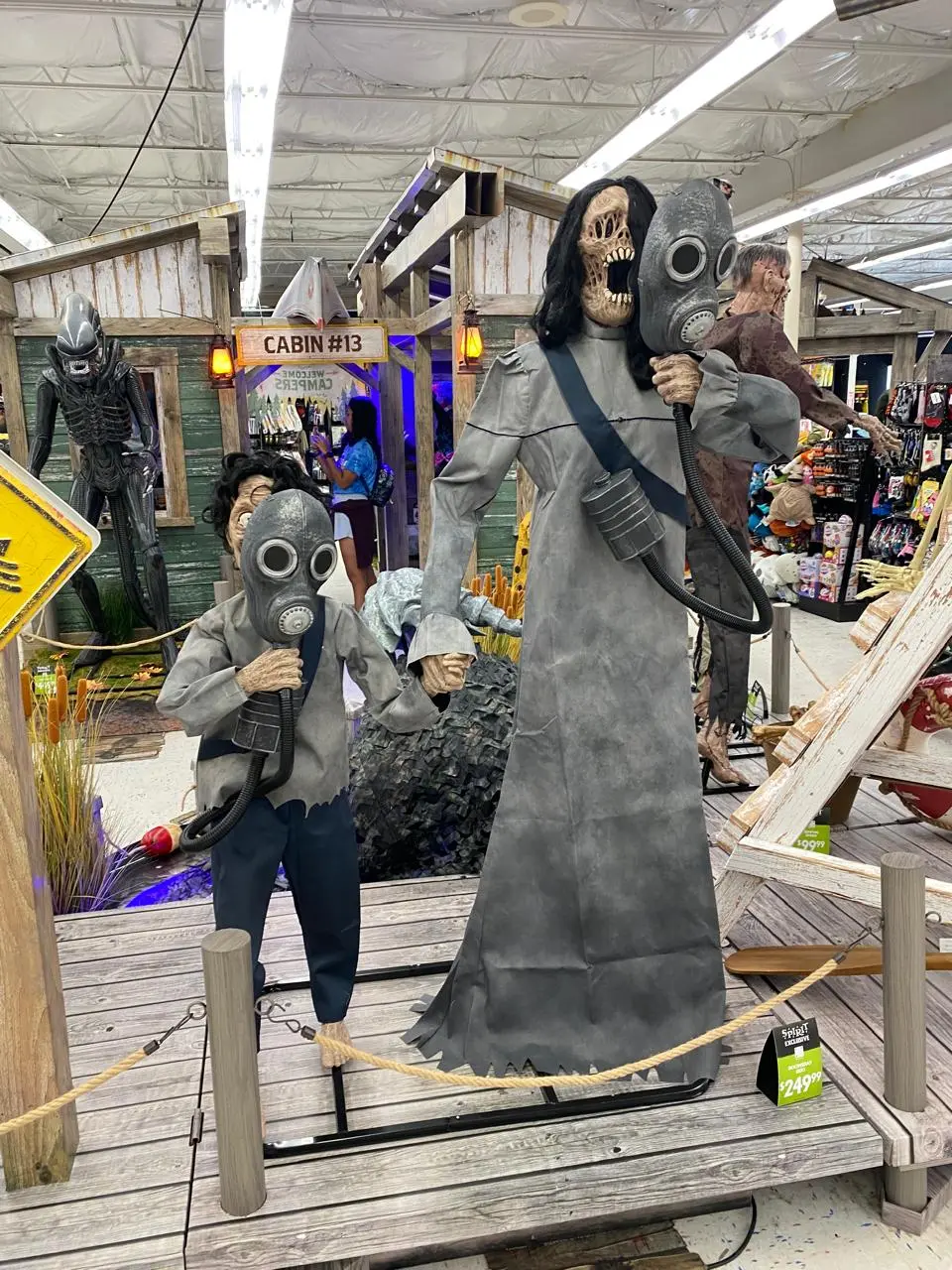 Animatrônicos de terror com máscaras de gás expostos dentro de uma loja Spirit Halloween