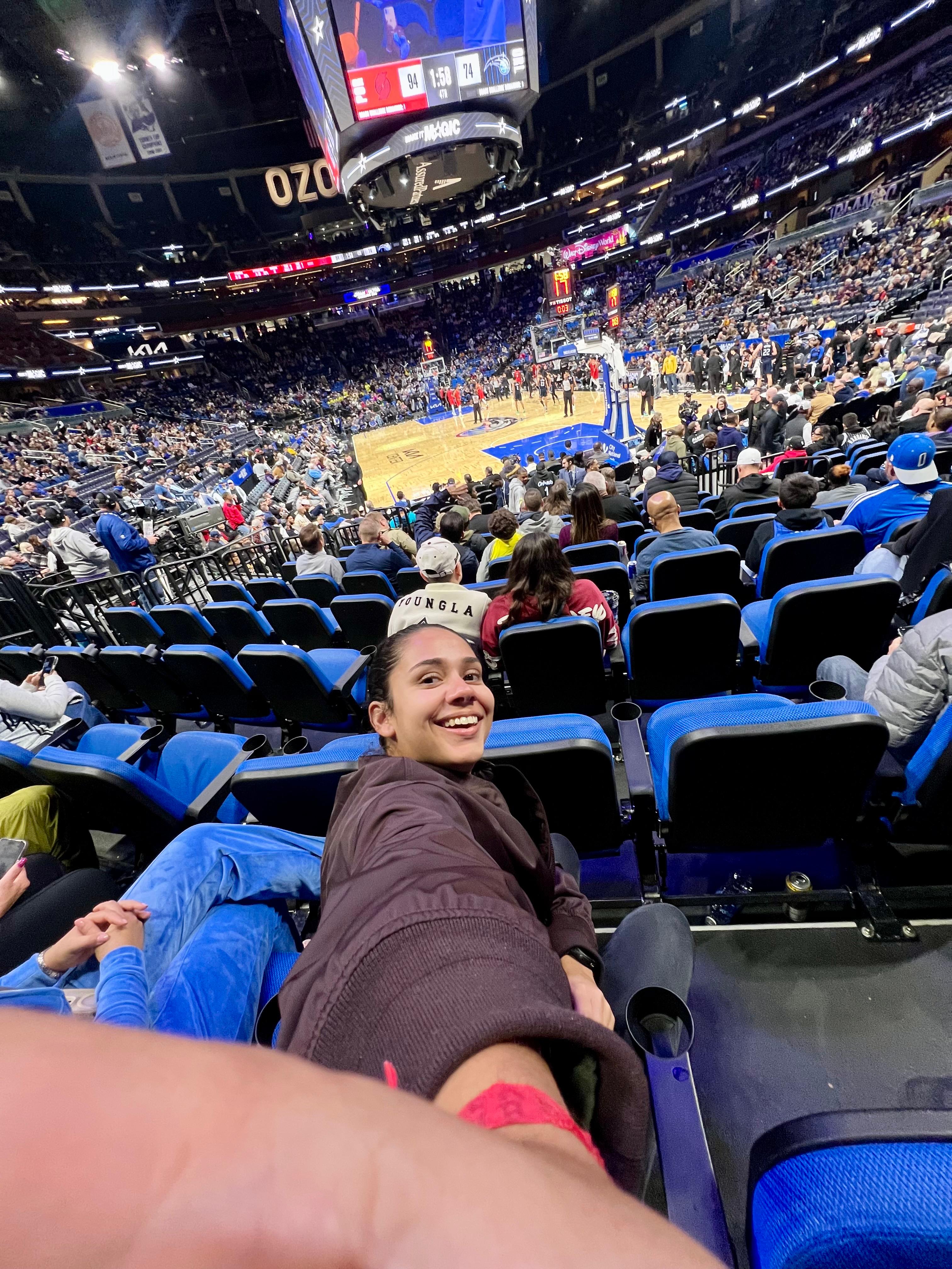 Beatriz da Talla Turismo assistindo a um jogo do Orlando Magic no Kia Center em Orlando, uma das experiências esportivas mais procuradas por turistas que visitam a Flórida.