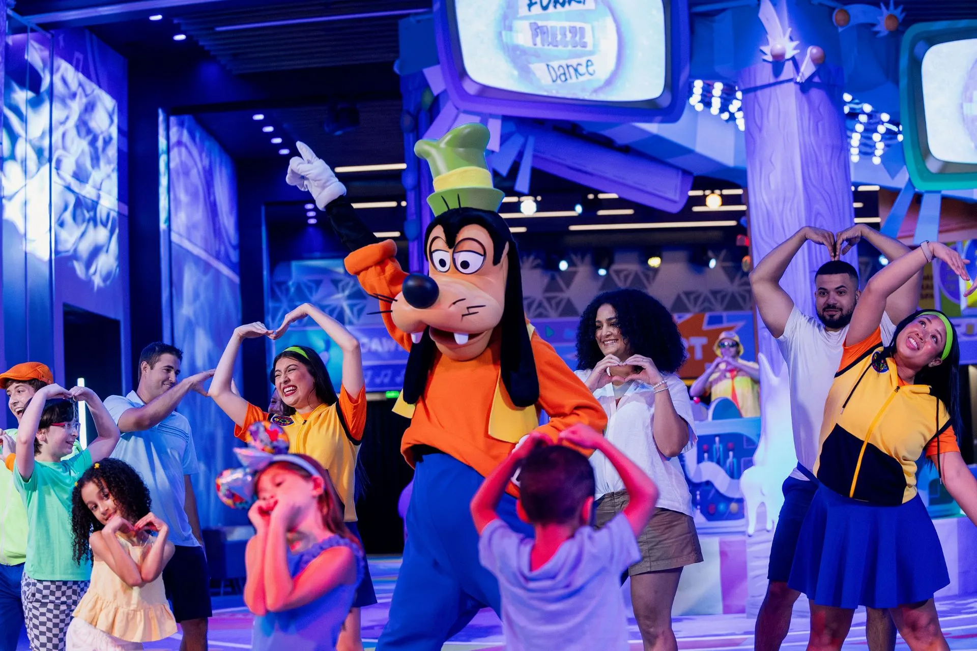 Pateta dançando com crianças e famílias durante o GoofyCore no EPCOT