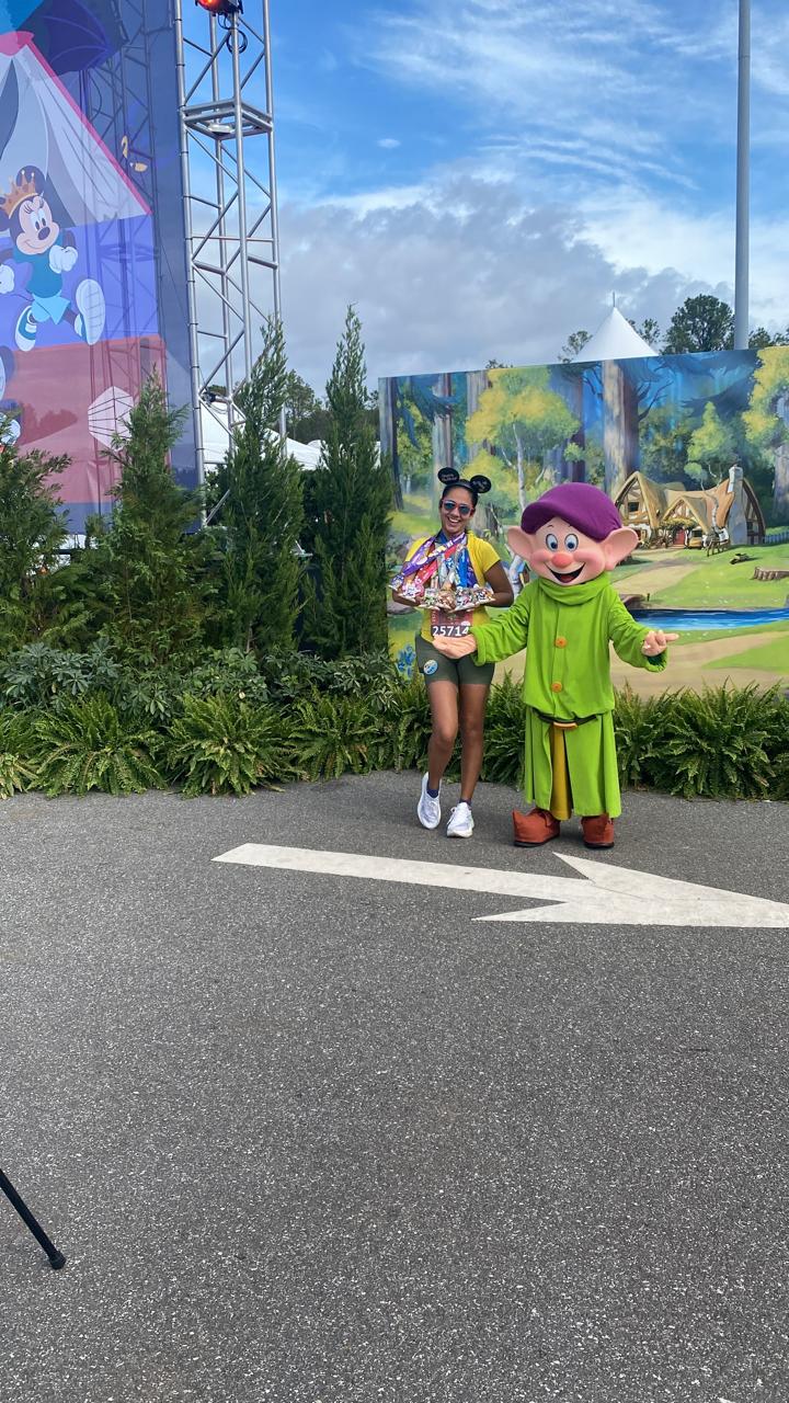 Beatriz da Tallaturismo na Walt Disney World Marathon Weekend posa ao lado do personagem Dunga durante uma prova da RunDisney em Orlando, celebrando a conquista de uma experiência única dentro do universo Disney