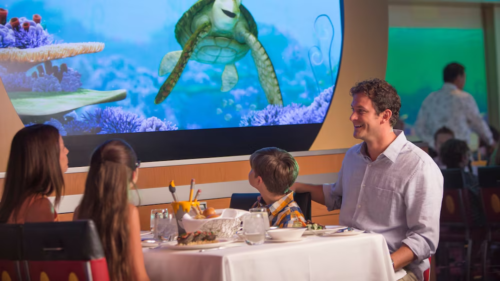 Família durante jantar no Animator’s Palate do Disney Fantasy, com Crush de Procurando Nemo na tela