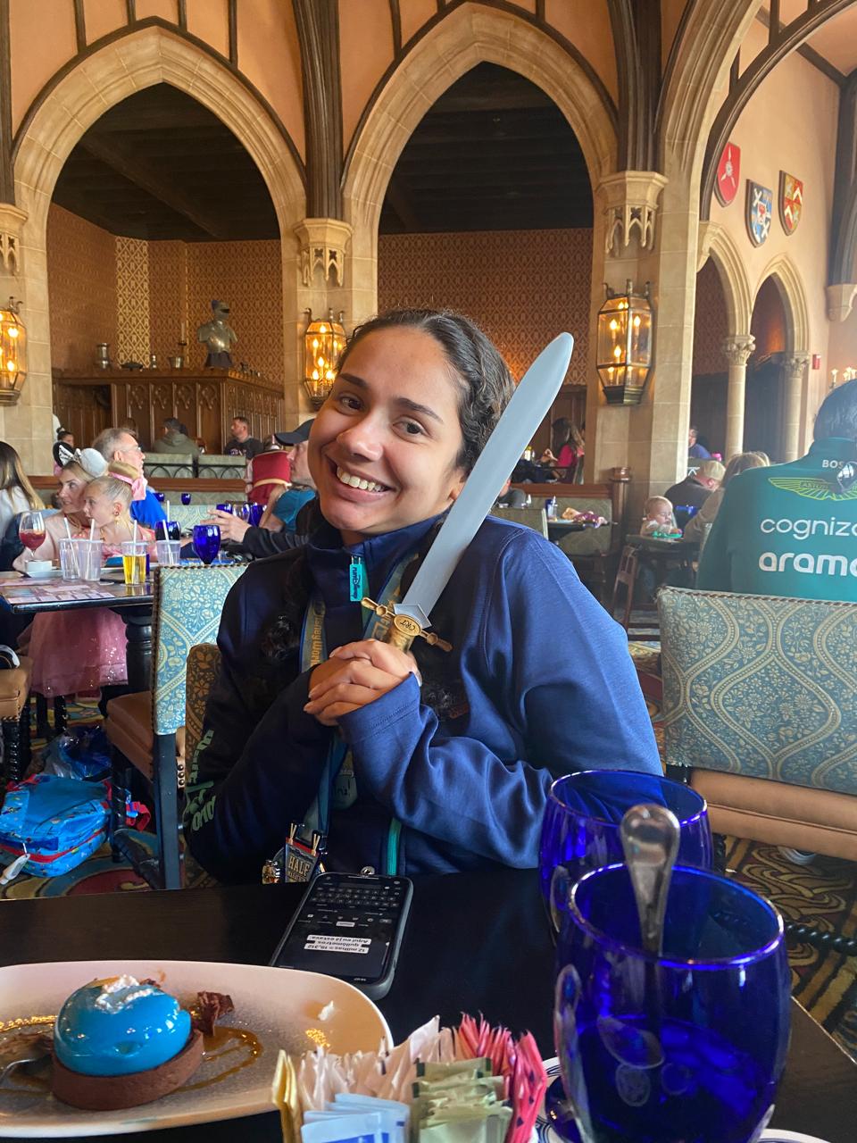 Beatriz da Talla Turismo segurando a espada do restaurante Cinderella's Royal Table durante uma refeição no Castelo da Cinderela, no Magic Kingdom