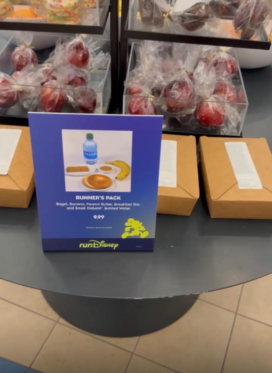 Kit de café da manhã para participantes da runDisney com banana, bagel, barra de cereal, manteiga de amendoim e água, preparado para os corredores que saem do hotel ainda de madrugada para a largada da prova.