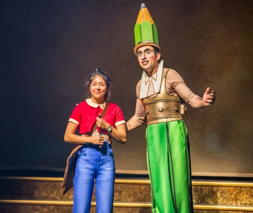 Cena do espetáculo Drawn to Life em Disney Springs mostrando Julie e um personagem inspirado em um lápis de animação, representando a criatividade e o processo artístico que dão vida às histórias da Disney