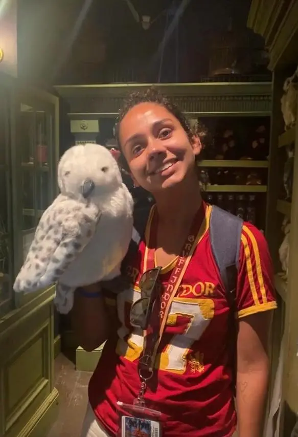 Visitante com coruja inspirada em Hedwig em área temática de Harry Potter no Universal Orlando Resort