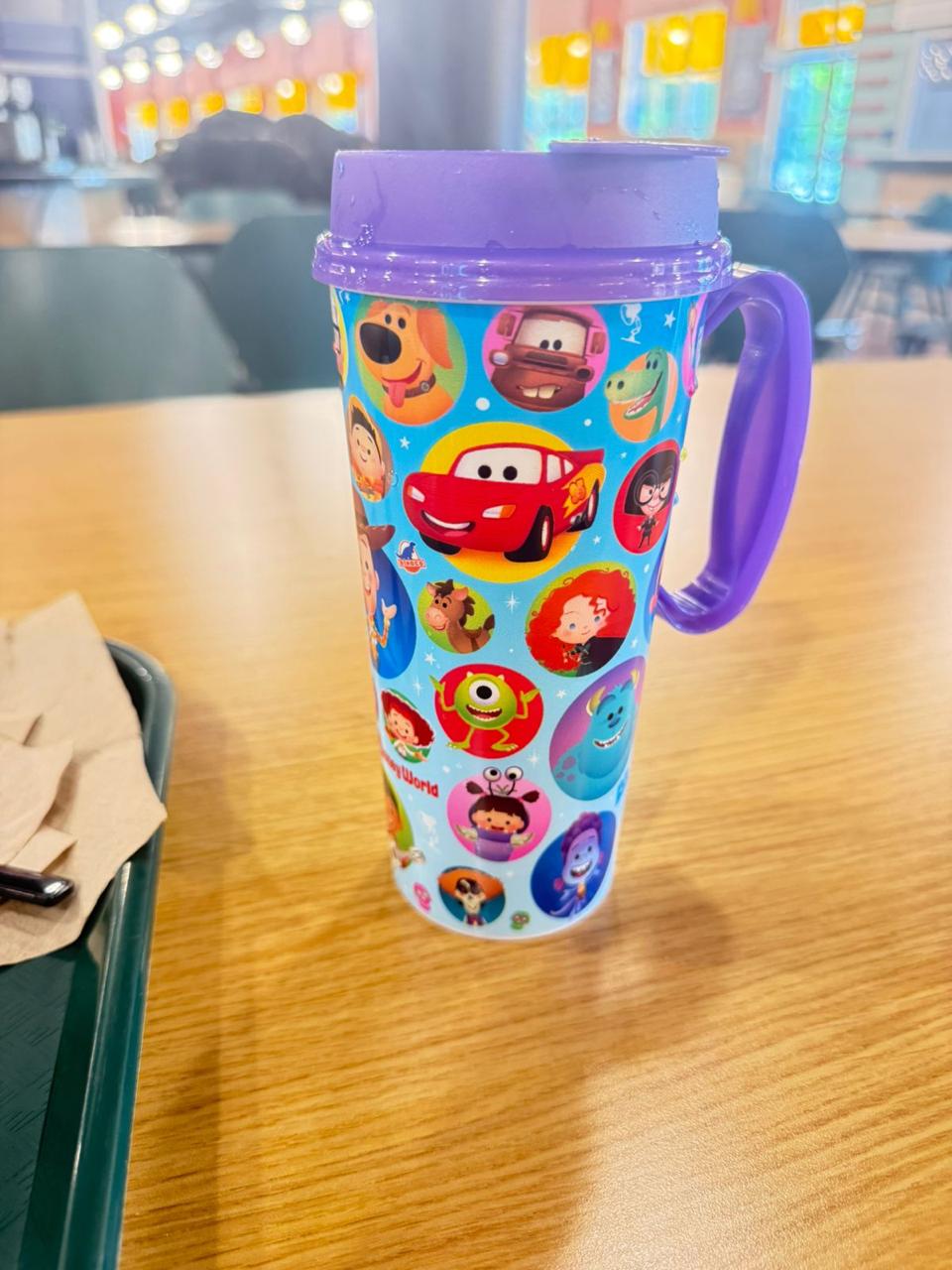 Caneca reutilizável Disney Resort Refillable Mug do Disney Dining Plan sobre a mesa de um restaurante do Walt Disney World Resort.