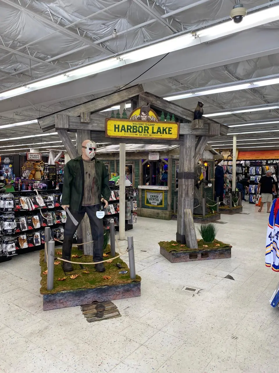 Área temática Harbor Lake dentro de uma loja Spirit Halloween com personagem de terror e produtos de Halloween