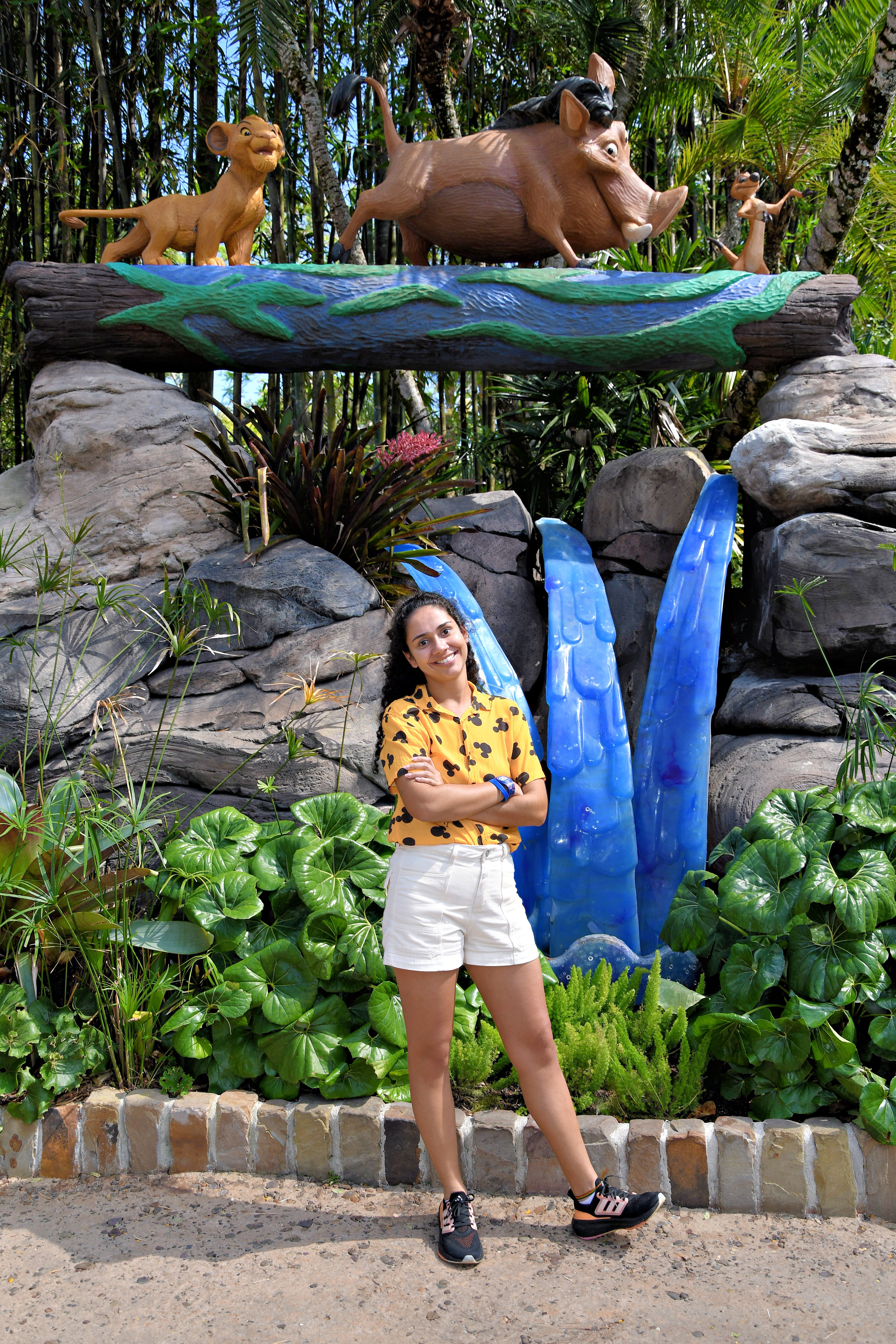 Beatriz, da Talla Turismo, posando em frente à escultura do Rei Leão com Simba filhote, Pumba e Timão no Disney's Animal Kingdom, Orlando